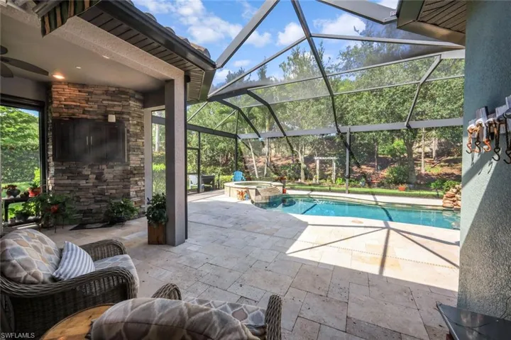 View of pool with a patio, a pool with connected hot tub, ceiling fan, and glass enclosure