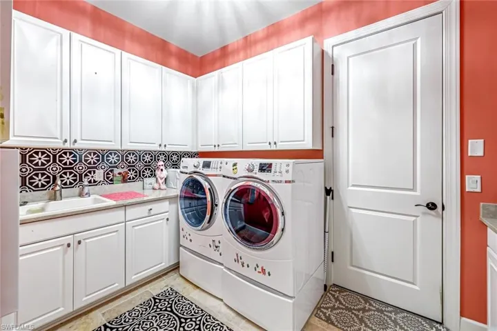 Laundry area featuring cabinet space, washing machine and clothes dryer, and light tile patterned floors