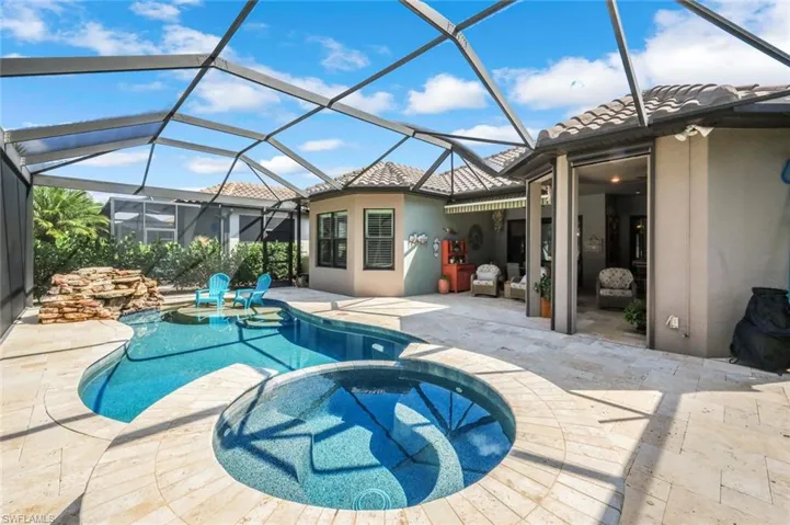 View of swimming pool with a patio area, a pool with connected hot tub, and a lanai