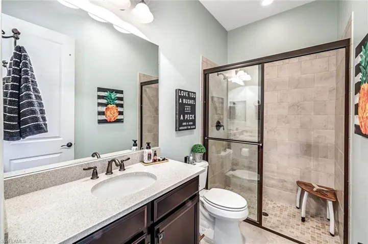 Full bathroom featuring a shower stall, vanity, and tile patterned floors