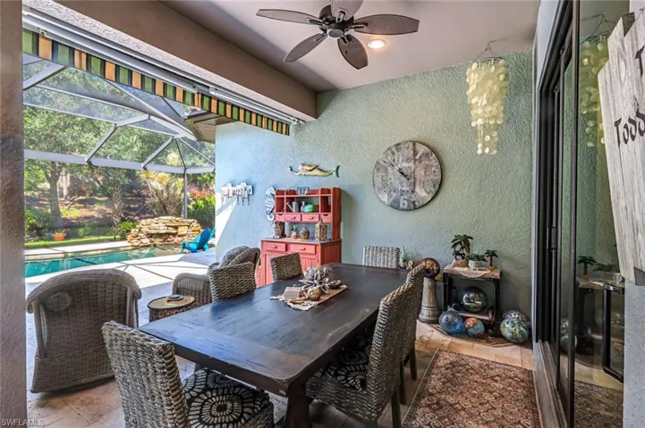 Dining space featuring a textured wall, a sunroom, ceiling fan, and light tile patterned floors