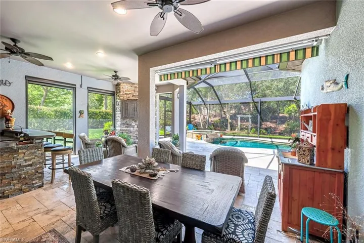 Dining area featuring a sunroom, stone tile floors, a ceiling fan, and a textured wall
