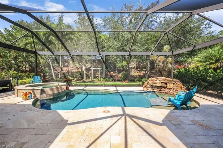 View of pool with a patio area, a pool with connected hot tub, and glass enclosure