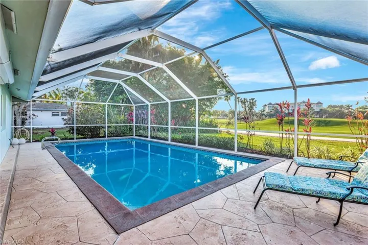 View of swimming pool featuring a patio area and screen enclosure