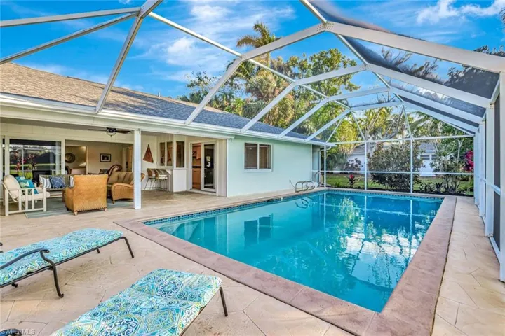 View of swimming pool featuring a patio, an outdoor hangout area, screen enclosure, and ceiling fan