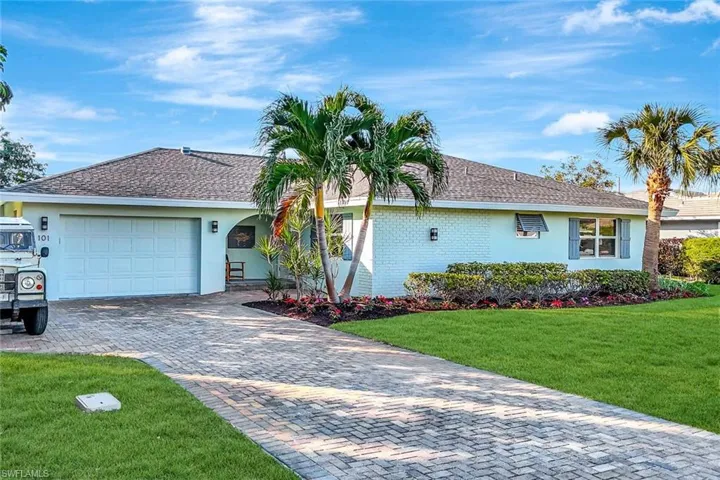 Ranch-style house featuring a front lawn and a garage