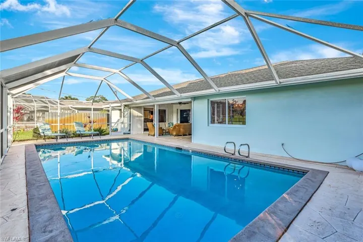 View of pool with a lanai, ceiling fan, and a patio