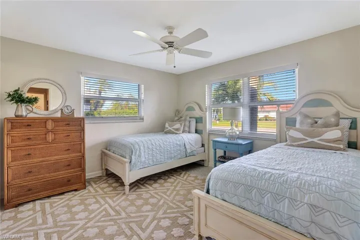 Bedroom with ceiling fan and light carpet