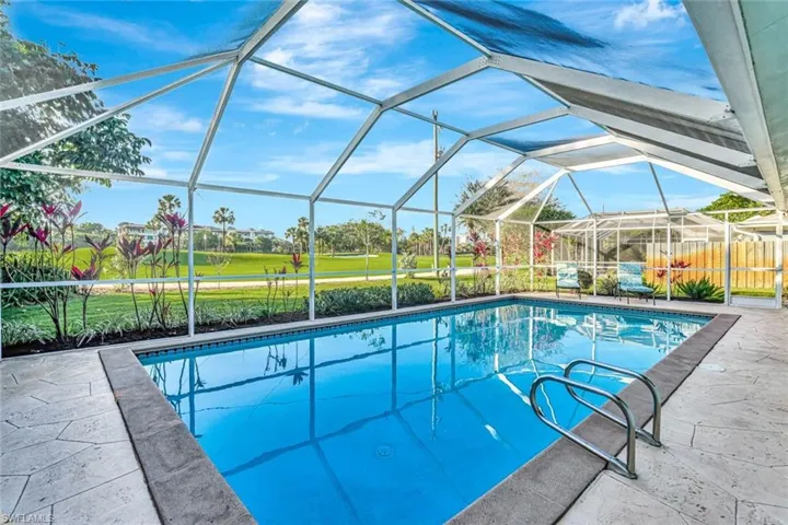 View of pool featuring screen enclosure and a patio