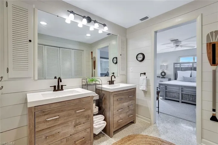 Bathroom featuring vanity, ship lap walls, and ceiling fan