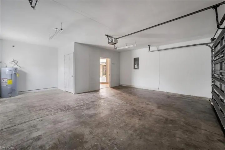 Garage featuring water heater and electric panel