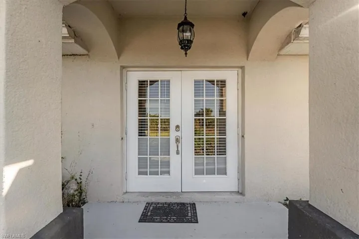 Property entrance with stucco siding, french doors, and a patio