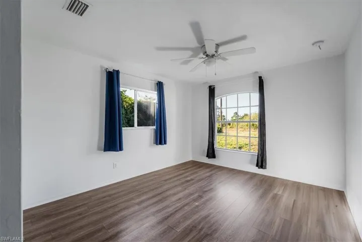 Empty room with wood finished floors and ceiling fan