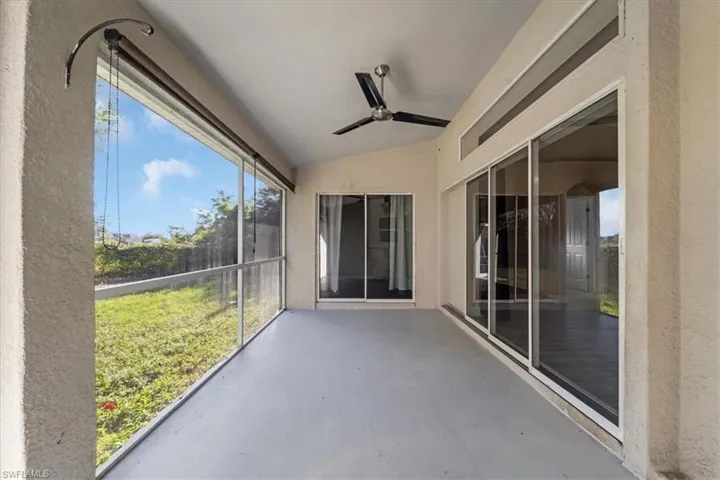 Unfurnished sunroom featuring a ceiling fan and vaulted ceiling