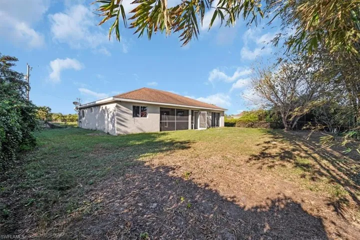 Back of house with a sunroom and a yard