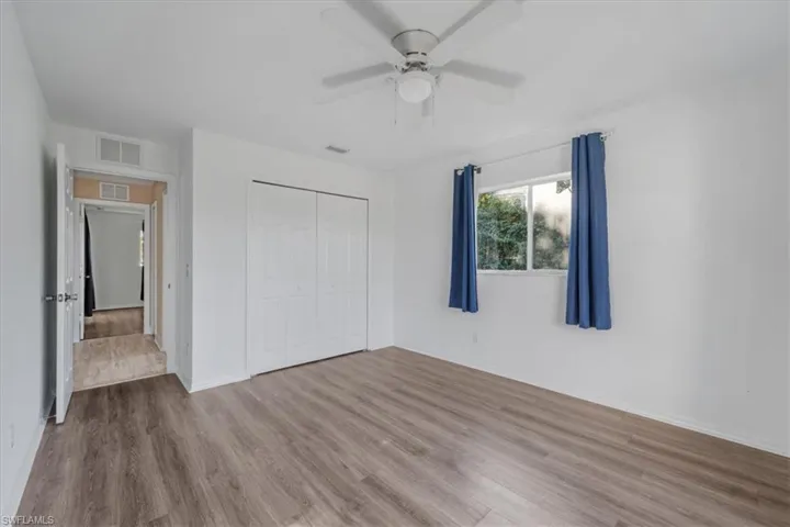 Unfurnished bedroom featuring wood finished floors, ceiling fan, and a closet