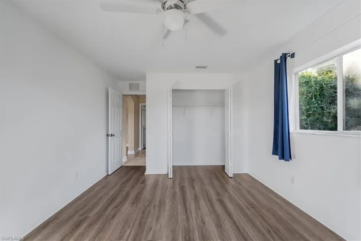 Unfurnished bedroom featuring wood finished floors, a closet, and a ceiling fan