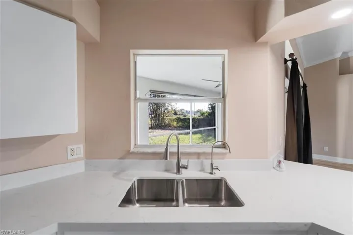 Kitchen with a sink and light stone countertops