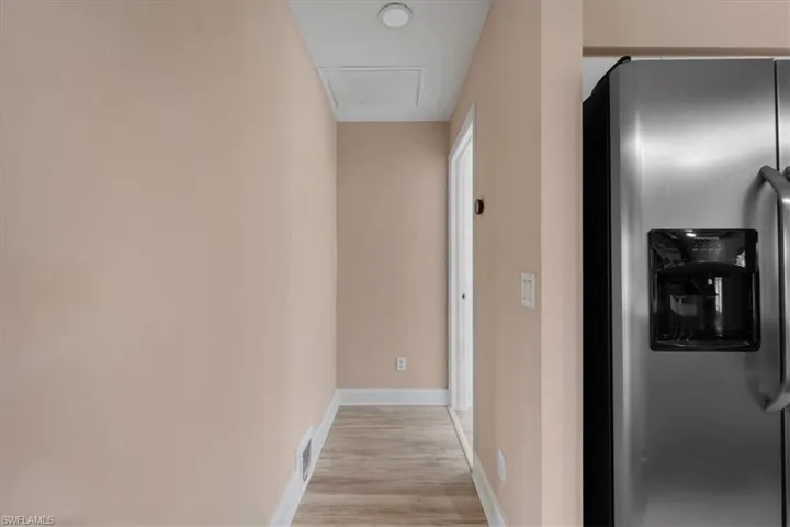 Corridor featuring baseboards and light wood-style floors