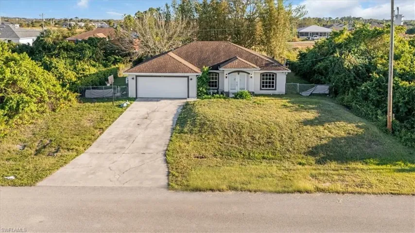 View of front facade with concrete driveway, an attached garage, and stucco siding