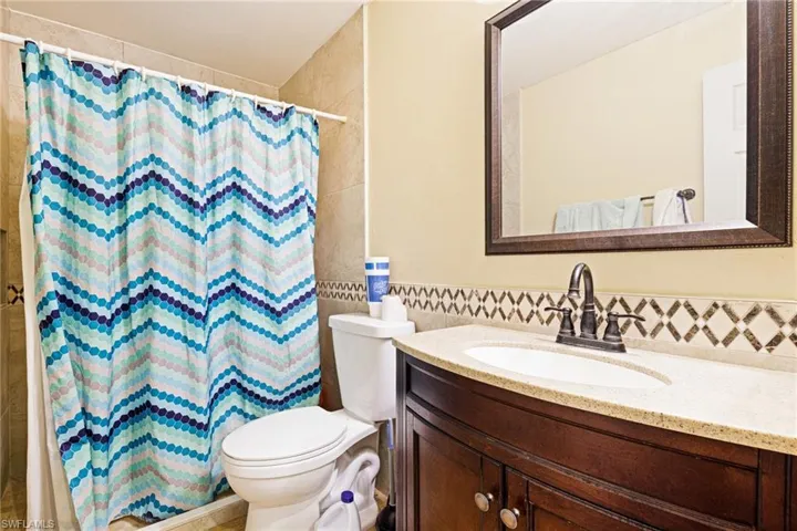 Bathroom with tile walls, vanity, and a shower with shower curtain