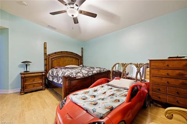 Bedroom featuring wood finished floors, lofted ceiling, and a ceiling fan