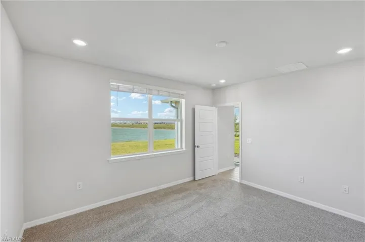 Empty room featuring recessed lighting, visible vents, and carpet floors