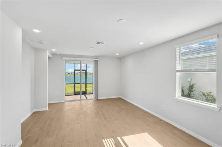 Empty room featuring light wood-type flooring, baseboards, and visible vents