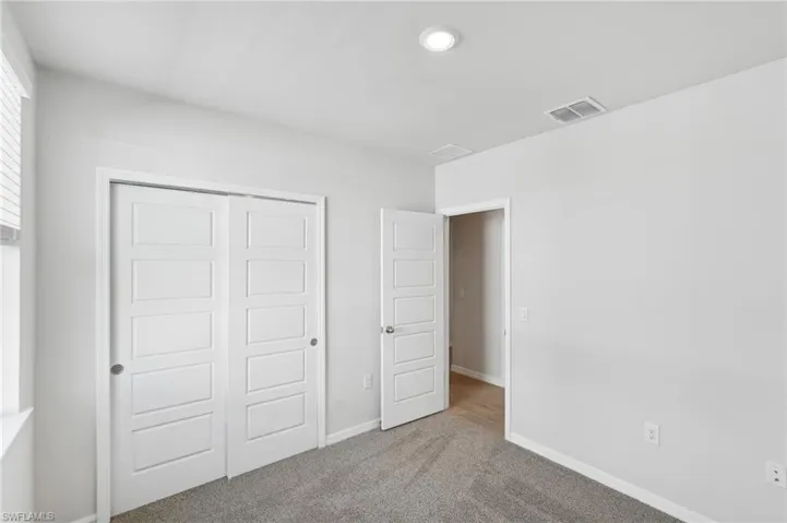 Unfurnished bedroom featuring visible vents, baseboards, a closet, carpet floors, and recessed lighting