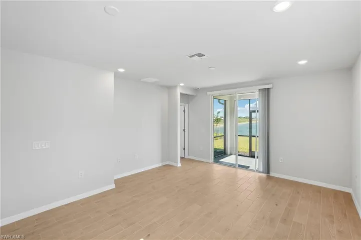 Unfurnished room with light wood finished floors, baseboards, visible vents, and recessed lighting