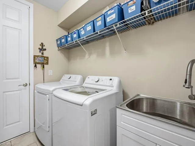 Laundry room featuring separate washer and dryer and tile patterned floors