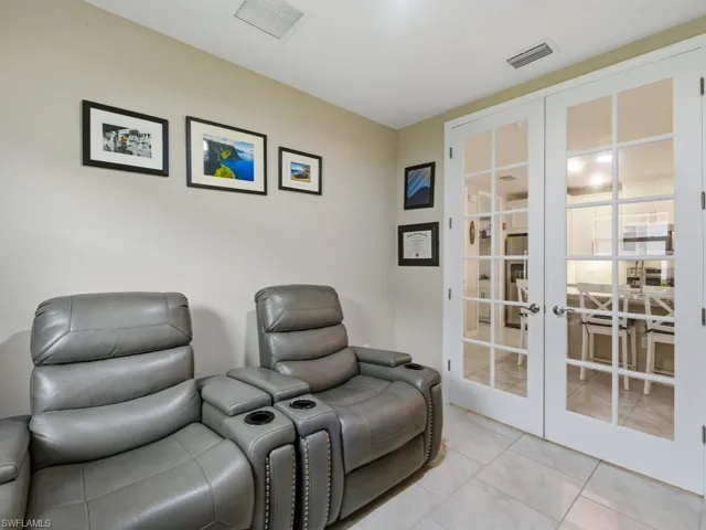 Matching tiled den with French doors use as an office or study or just a quiet room