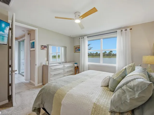 Bedroom featuring a water view, a ceiling fan with light, and brand new carpet just installed-furniture conveys including two lamps and two round mirrors