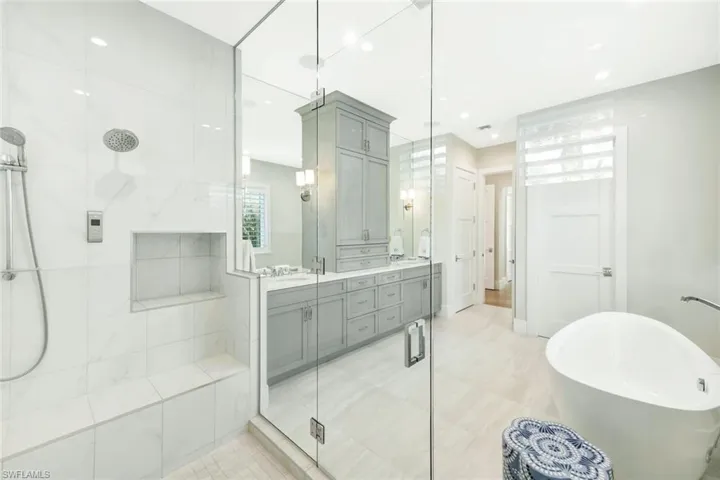 Bathroom with double vanity, a soaking tub, and a stall shower
