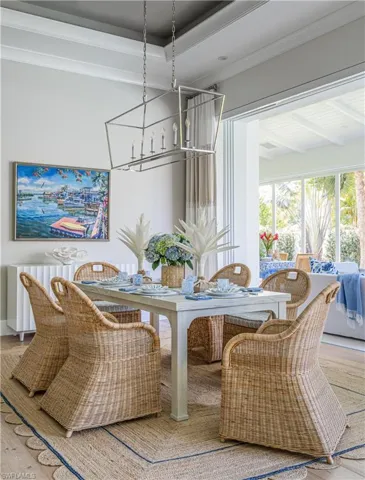 Dining area featuring wood-type flooring, crown molding, and a chandelier