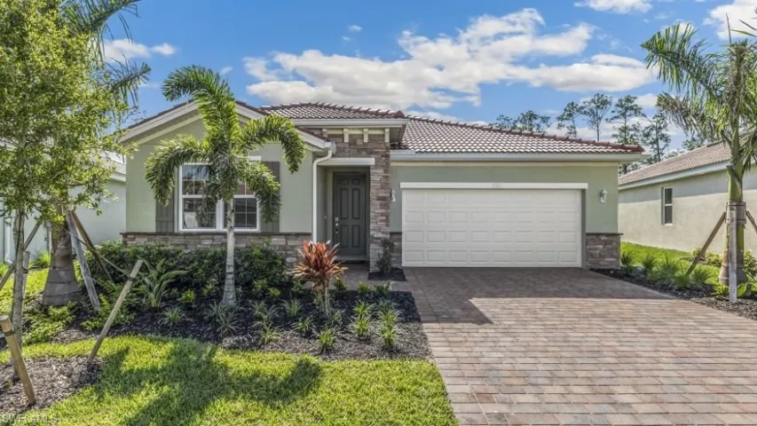 Model home. Mediterranean / spanish house with an attached garage, driveway, and stucco siding