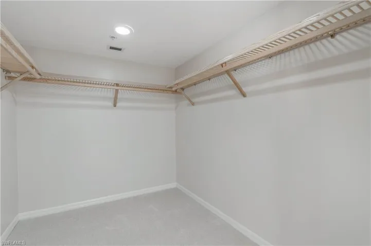 Walk in closet with carpet floors and visible vents