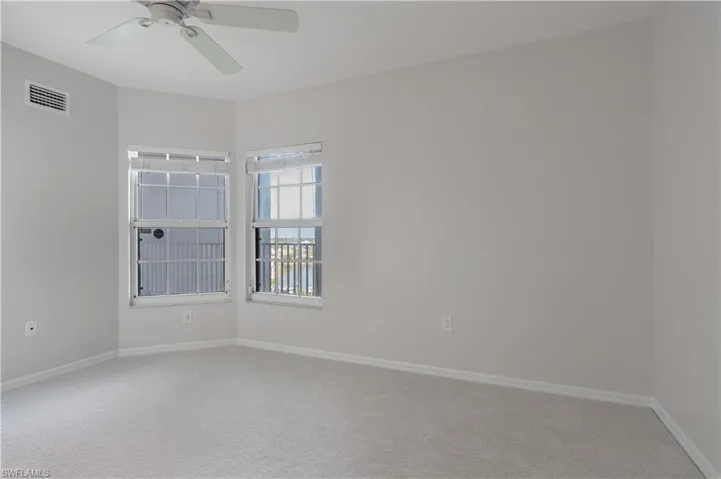 Unfurnished room featuring ceiling fan, carpet flooring, visible vents, and baseboards