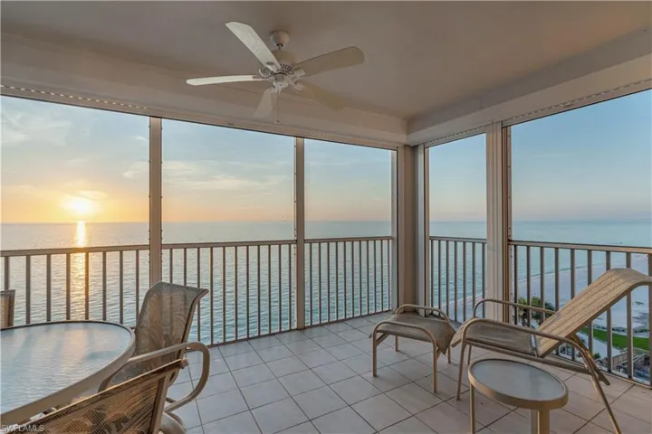Sunroom with a water view, ceiling fan, and a wealth of natural light