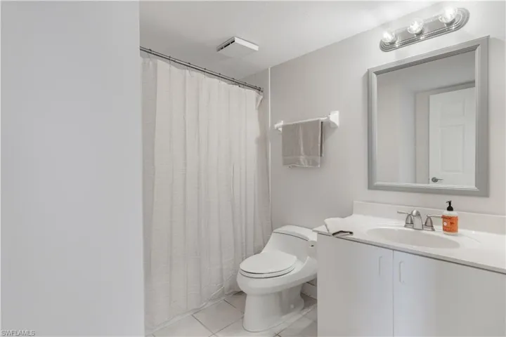 Full bathroom featuring toilet, vanity, and tile patterned floors