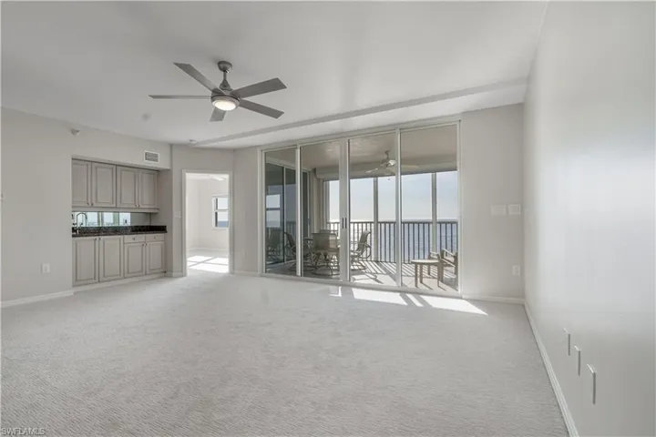 Spare room featuring ceiling fan, baseboards, and light colored carpet