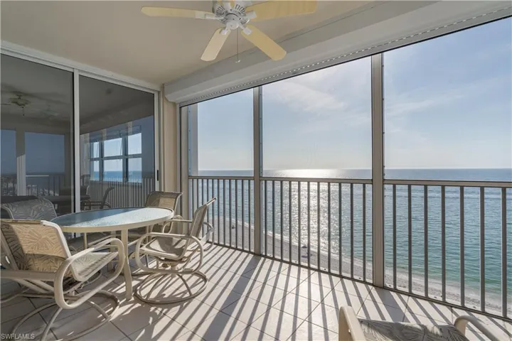 Sunroom / solarium featuring a water view, plenty of natural light, and a beach view