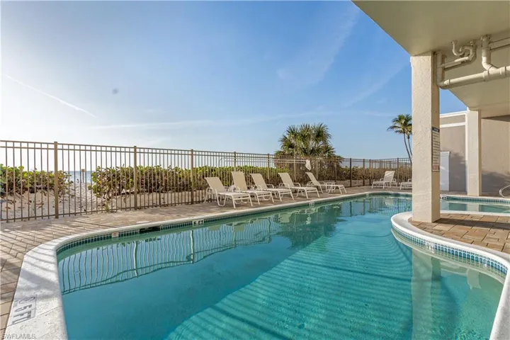 Pool with a patio area and fence