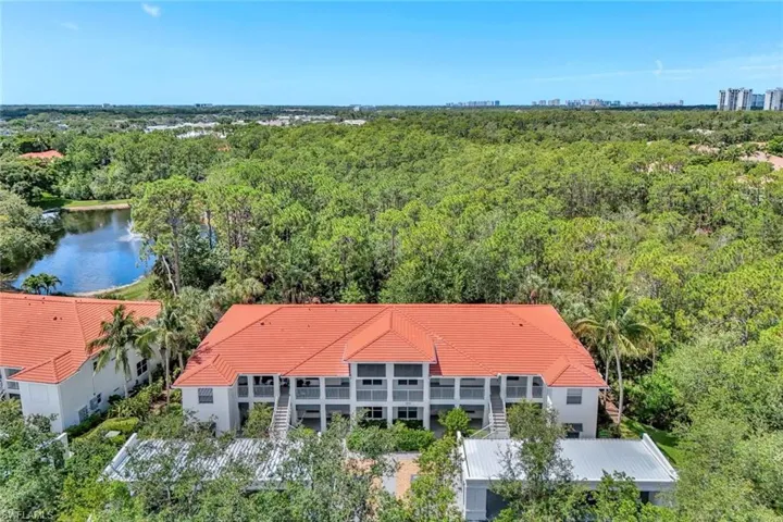 View of subject property with a heavily wooded area and a large body of water