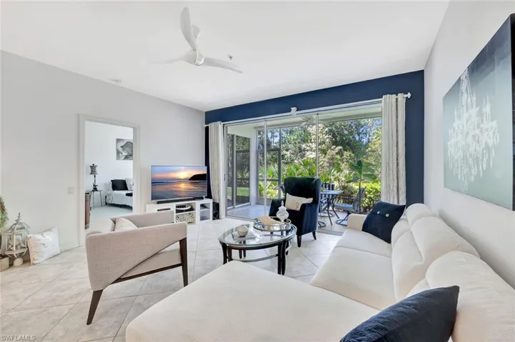 Living area featuring light tile patterned flooring and ceiling fan