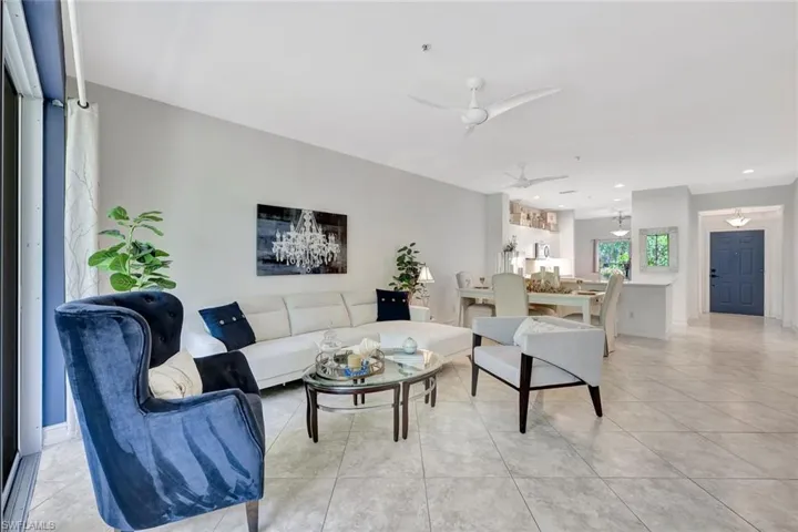 Living room with light tile patterned floors and ceiling fan