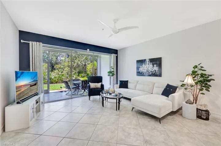 Living room featuring light tile patterned flooring and ceiling fan