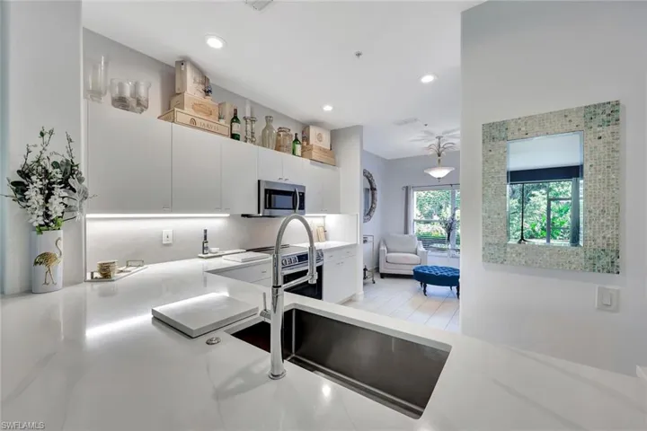 Kitchen featuring appliances with stainless steel finishes, recessed lighting, light countertops, white cabinets, and decorative backsplash