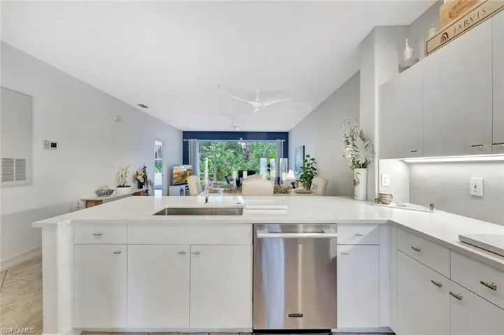 Kitchen with stainless steel dishwasher, a peninsula, white cabinets, and open floor plan