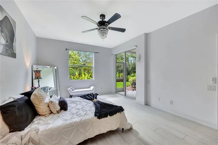 Bedroom with access to exterior, ceiling fan, and wood finished floors